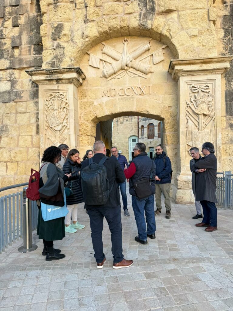 Participants of the RESWATER kick-off meeting learning about the three-gate system at the Couvre Porte and its strategic role in protecting Birgu’s water supply.